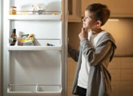 niño mirando frigorífico abierto