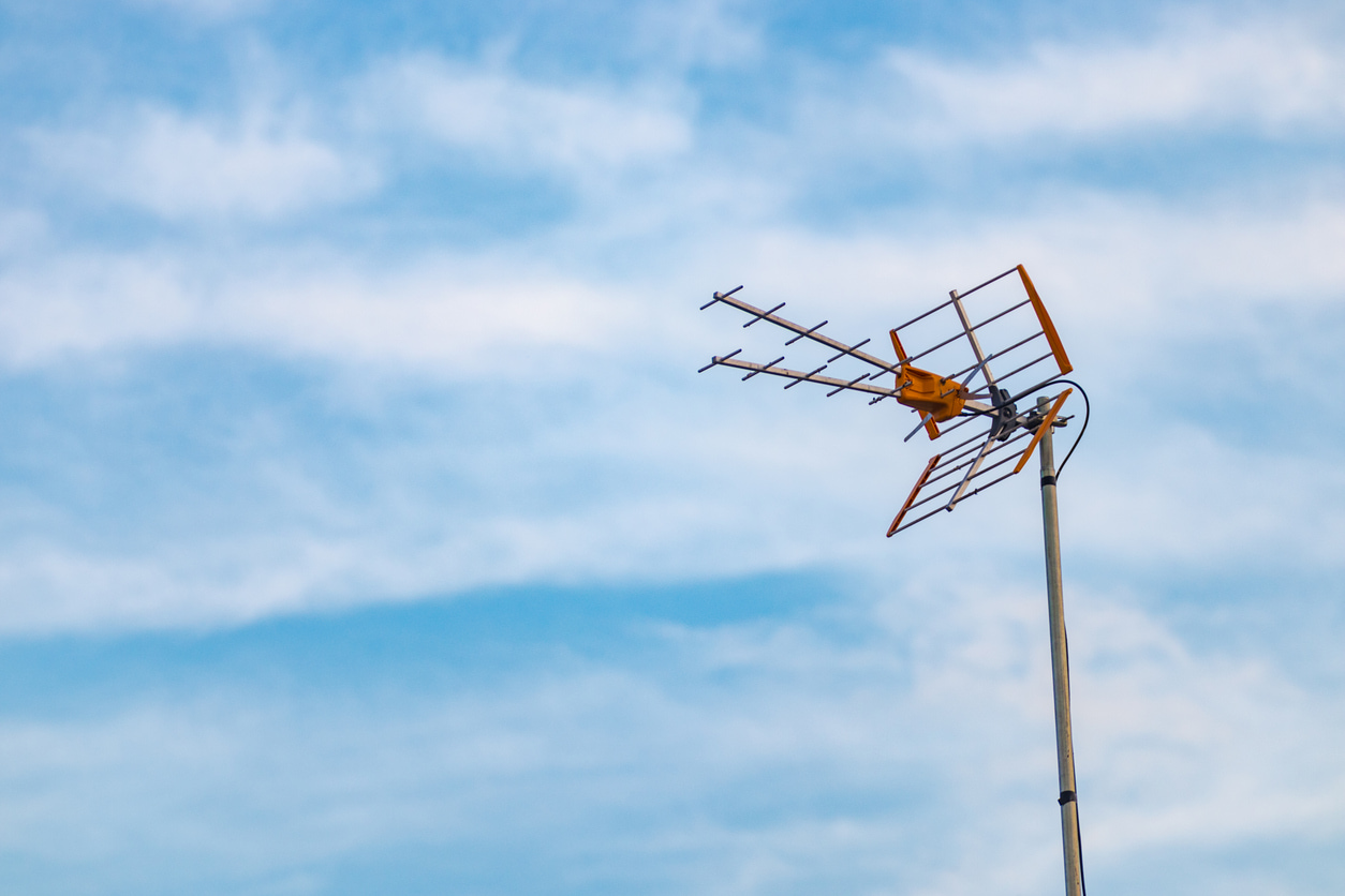 Una antena de tv en lo más alto del exterior de una casa.