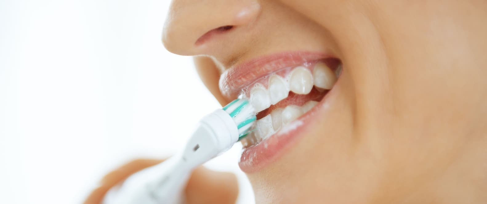 Una mujer se cepilla los dientes.