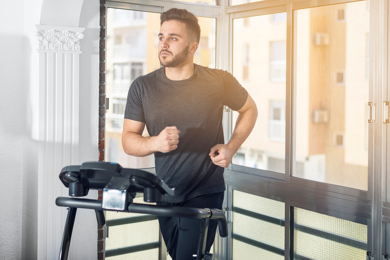Un hombre entrena en su cinta de correr de casa.