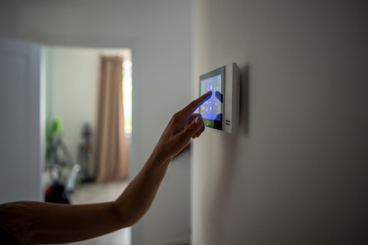 Una mujer configura la domótica del hogar en un panel táctil.