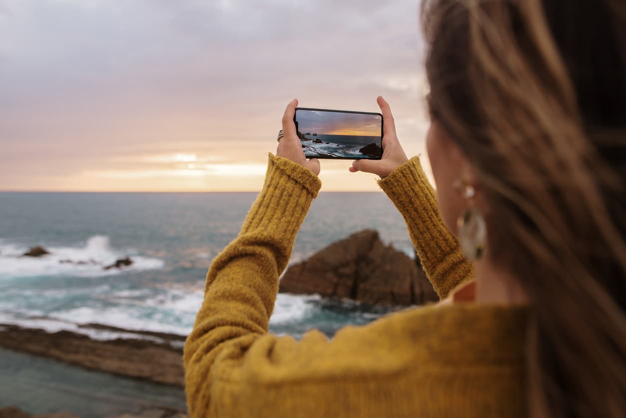 Una mujer hace una fotografía del paisaje con su teléfono móvil.