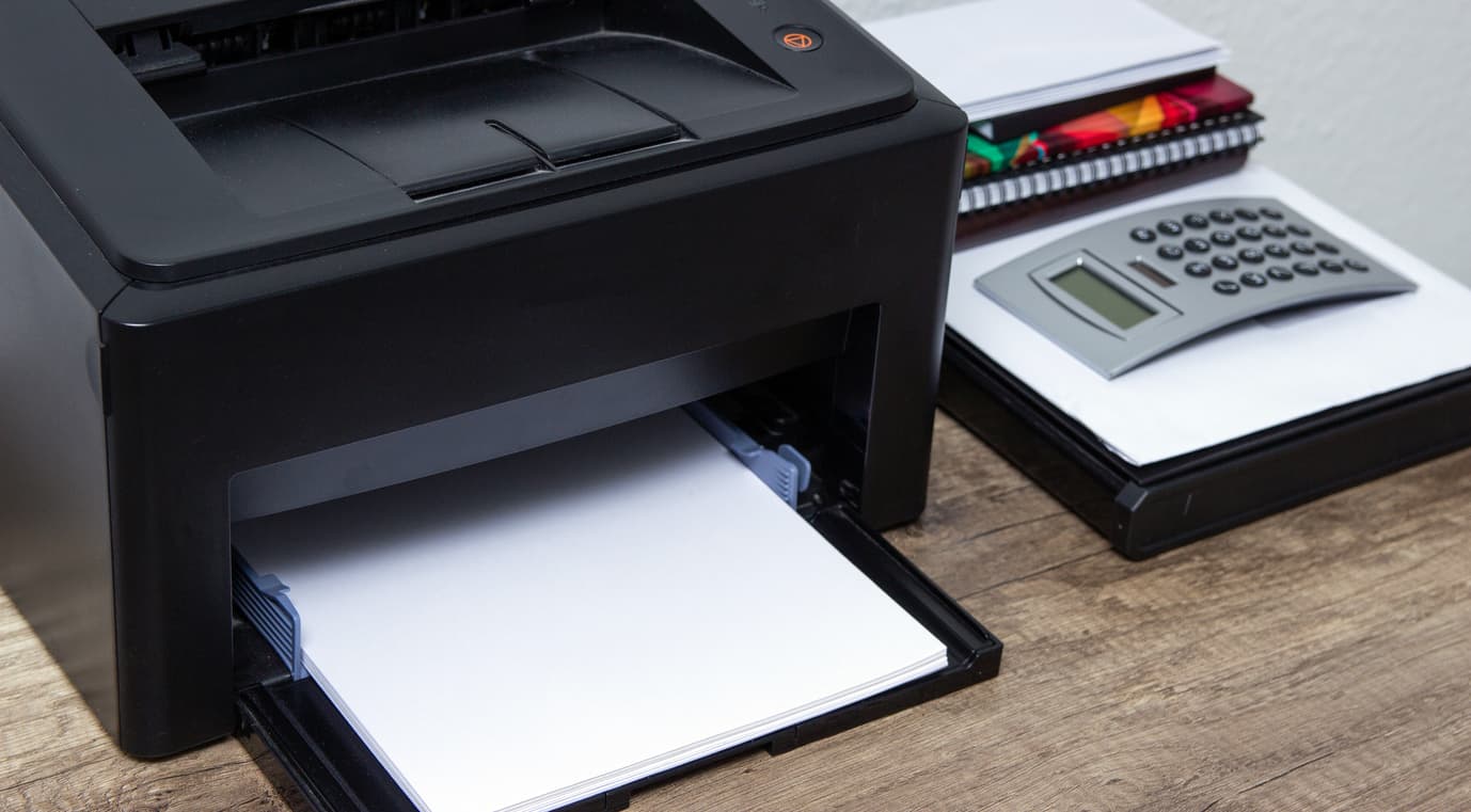 La impresora y la calculadora del estudio sobre la mesa.
