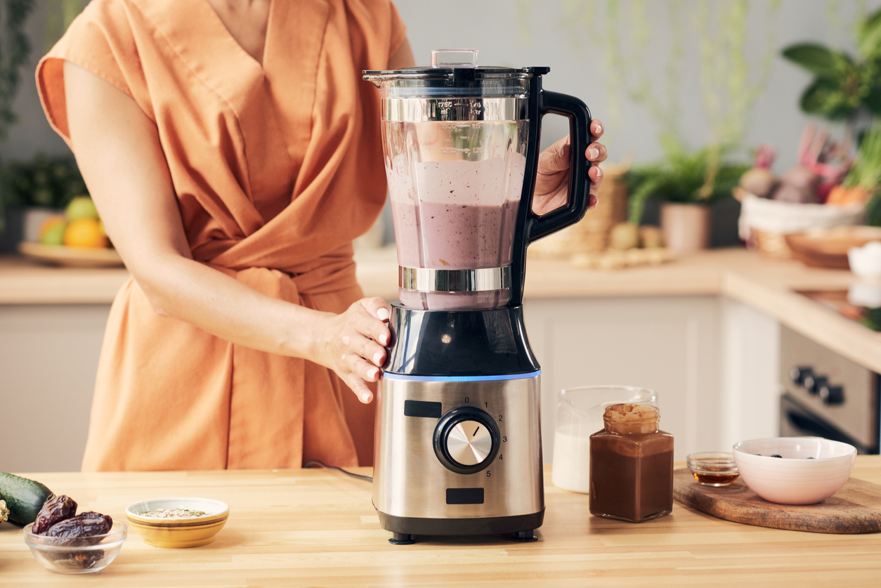 Una mujer hace un batido con la licuadora.