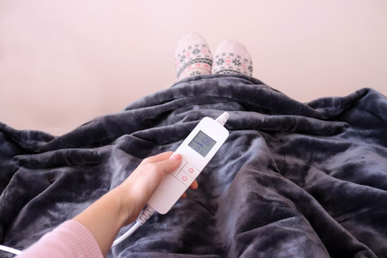 Una manta eléctrica protege a una niña del frío en invierno.