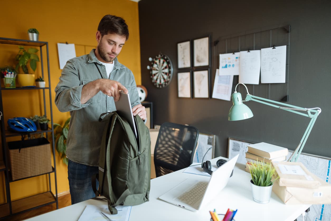 Un hombre recoge el ordenador en su mochila para el portátil.