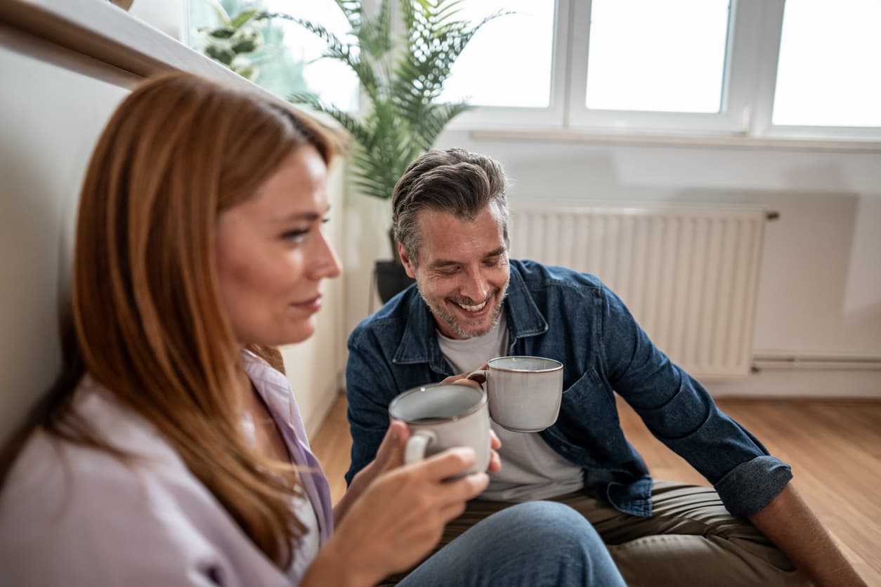 Una pareja se protege del frio con un radiador pequeño.