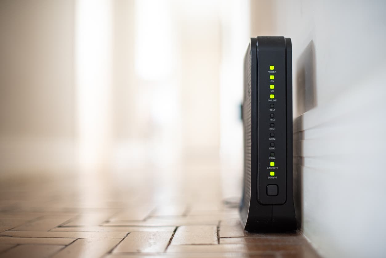 Un router negro encendido para dar conexión a todo el hogar.