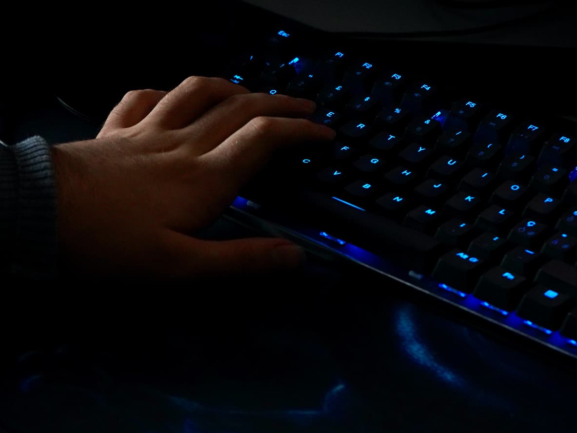 Una mano lanzando las habilidades de su campeón con el teclado gaming.