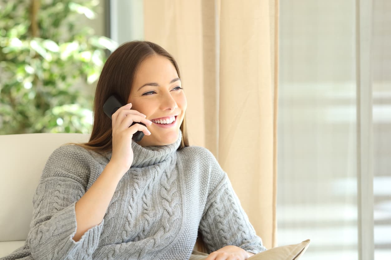 Una mujer habla a través del teléfono fijo.