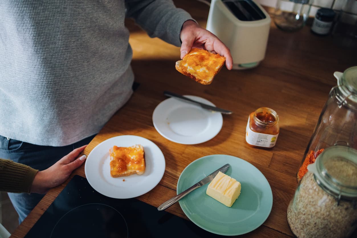El desayuno de tostadas con mantequilla y frambuesa.