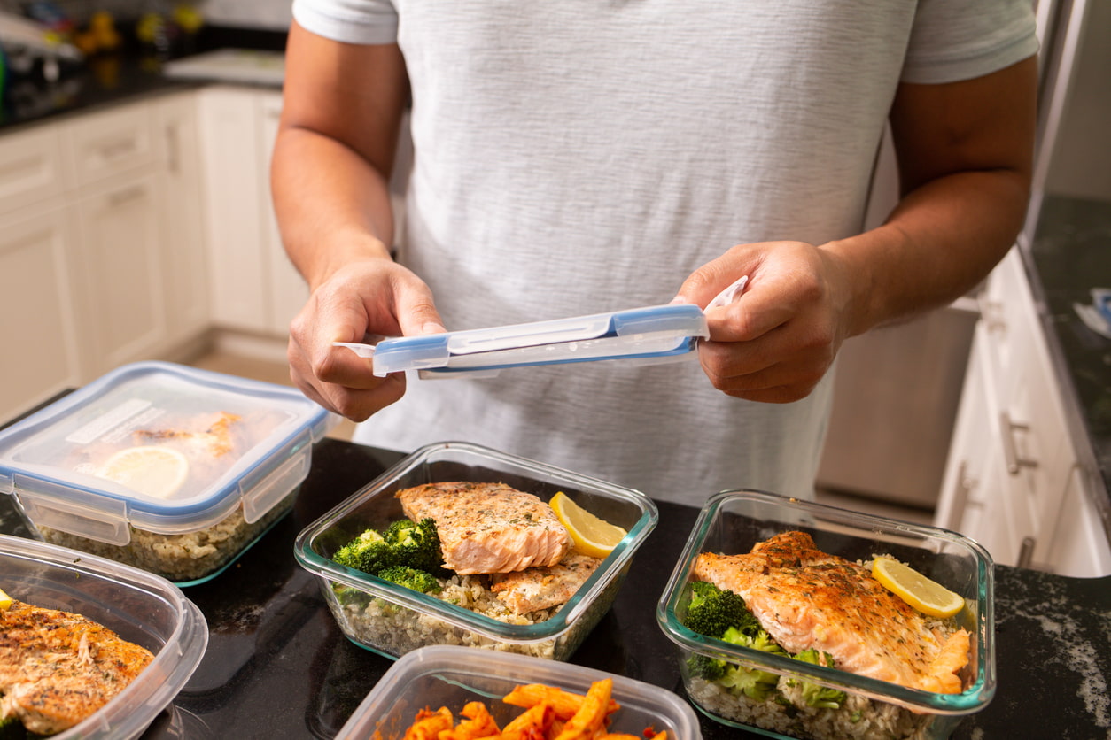 Un hombre prepara tuppers con comida para toda la semana.